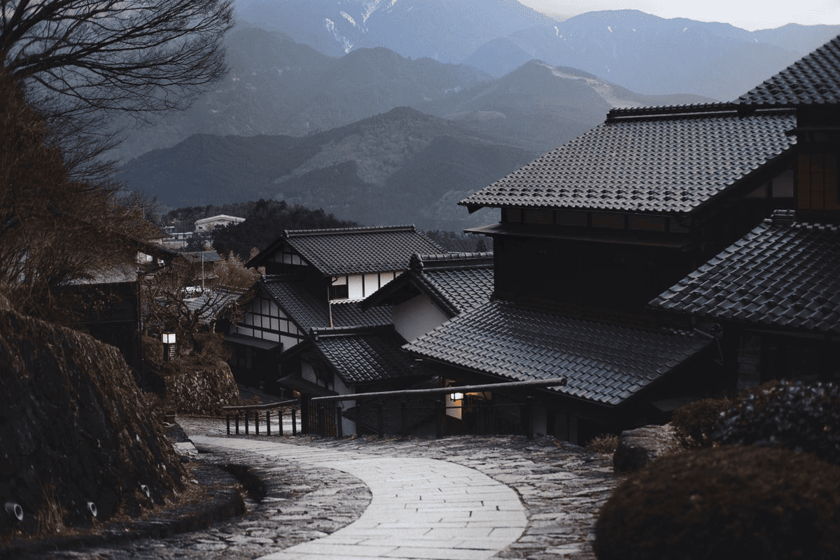 Mountain village with tiled roofs and a winding stone road.